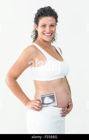 Schwangere Frau mit einer Ultraschalluntersuchung lächelnd Stockfoto