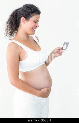 Schwangere Frau betrachten Ultraschalluntersuchung Stockfoto