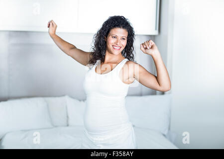 Schöne schwangere Frau im Schlafzimmer Stockfoto