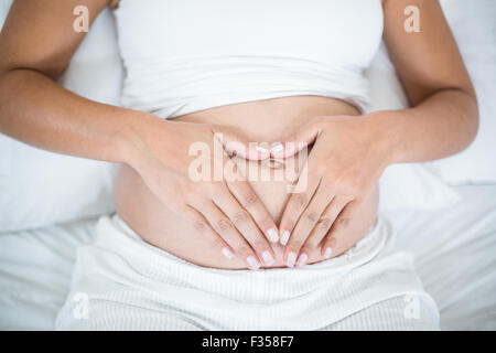 Nahaufnahme der schwangeren Frau Herzschild auf den Bauch zu tun Stockfoto