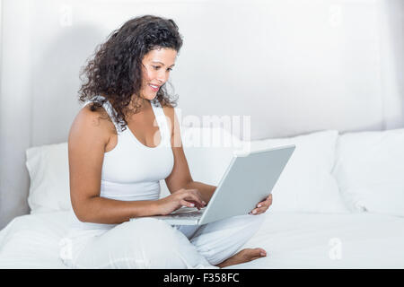 Schöne lächelnd schwangere Frau mit laptop Stockfoto