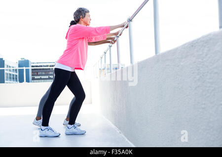 Frauen stützte sich auf Geländer während des Trainings Stockfoto