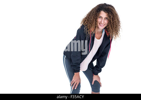 Glückliche junge Frau mit Hand am Knie biegen Stockfoto