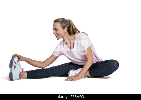 Fröhliche Frau, die Zehen zu berühren, während der Ausübung Stockfoto