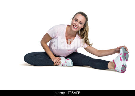 Fröhliche Frau, die Zehen zu berühren, während der Ausübung Stockfoto