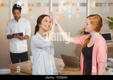 Glücklich Geschäftsfrauen geben hohe fünf im Büro Stockfoto