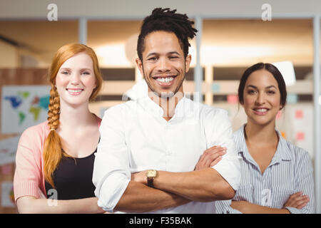 Geschäftsmann mit weiblichen Kollegen stehen mit verschränkten Armen Stockfoto