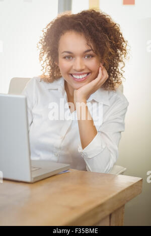 Lächelnde Geschäftsfrau mit Hand am Kinn Stockfoto
