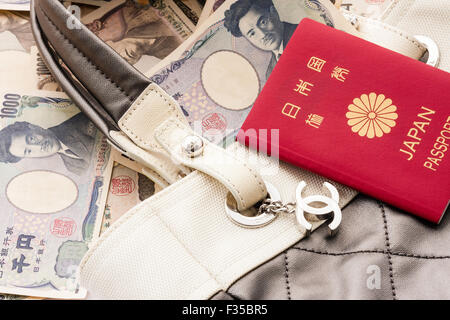 Nahaufnahme Detail einer Marke Chanel name Designer Tasche mit Metall logo Tag, CC und Japanischen Pass- und Yen Banknoten Stockfoto