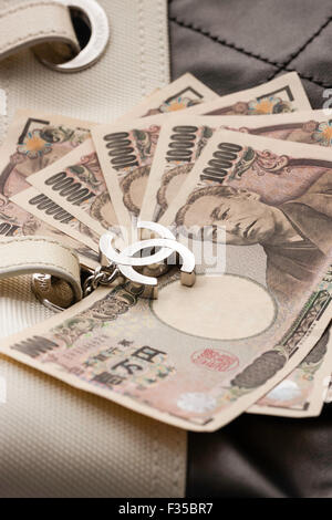 Nahaufnahme Detail einer Marke Chanel name Designer Tasche mit Metall logo Tag, CC und Japanischen Yen Banknoten. Stockfoto