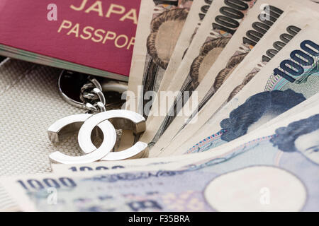 Nahaufnahme Detail einer Marke Chanel name Designer Tasche mit Metall logo Tag, CC und Japanischen Pass- und Yen Banknoten Stockfoto