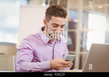 Geschäftsmann mit Smartphone im Büro Stockfoto