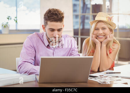 Business-Frau mit Hut von männlichen Kollegen sitzen Stockfoto