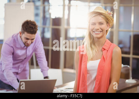 Business-Frau trägt Hut tatenlos männlicher Kollege Stockfoto