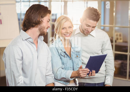 Geschäftsfrau hält Laptop Stand mit männlichen Kollegen Stockfoto