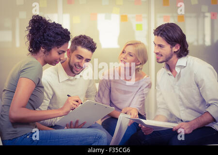 Geschäftsfrau zeigt Dokumente an Kollegen Stockfoto