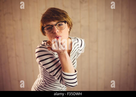 Hübsche junge Frau bläst Küsse Stockfoto