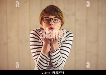 Hübsche junge Frau bläst Küsse Stockfoto