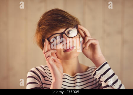 Hübsche Rothaarige halten ihre Lesebrille Stockfoto