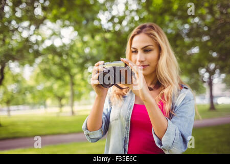 Frau Holding Kamera im park Stockfoto
