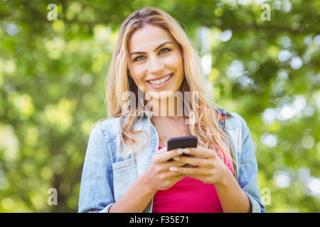 Porträt der lächelnde Frau mit gedrückter smartphone Stockfoto