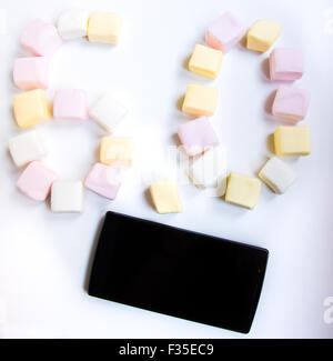 Handy mit farbigen Marshmallows Bonbons Stockfoto