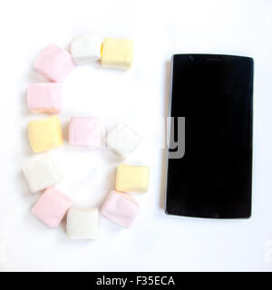 Handy mit farbigen Marshmallows Bonbons Stockfoto