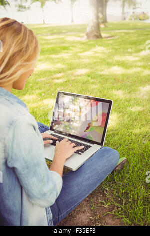 Frau mit Laptop sitzend im park Stockfoto