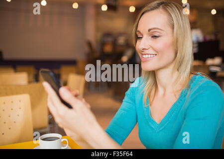 Junge Frau lächelnd mit Handy Stockfoto