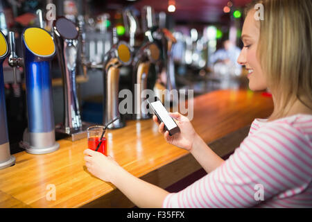 Junge Frau mit Handy mit Glas Stockfoto