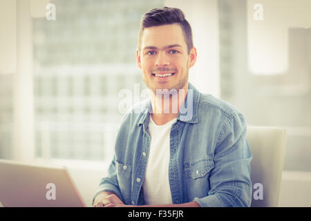 Porträt von lächelnden jungen Mann mit laptop Stockfoto