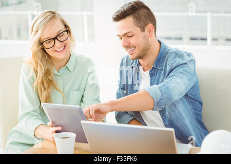 Lächelnde Frau mit Mann mit gedrückter digital-Tablette zu diskutieren Stockfoto