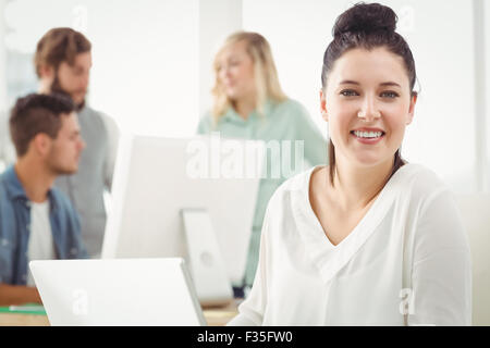 Porträt von lächelnden Geschäftsfrau auf laptop Stockfoto