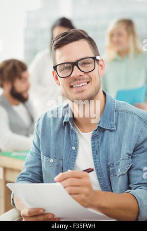 Porträt von lächelnder Mann halten Sie Papier und Stift Stockfoto