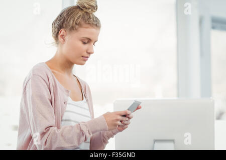 Frau mit Smartphone im Büro Stockfoto