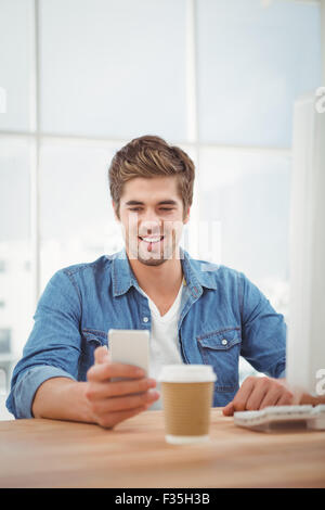 Glücklich lächelnd beim Handy betrachten hipster Stockfoto