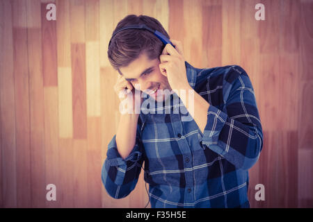 Hipster Lächeln während des Tragens Kopfhörer Stockfoto