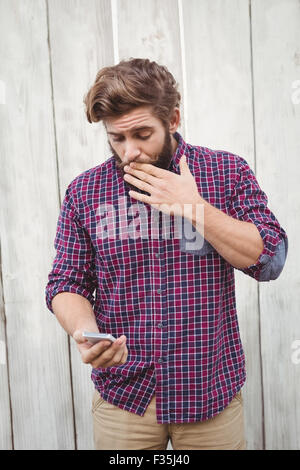 Schockiert Hipster Blick auf mobile Stockfoto