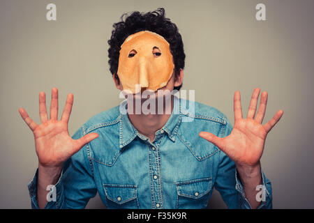 Junger Mann hat gebt in einen Pfannkuchen geschnitten und trägt es auf seinem Gesicht Stockfoto