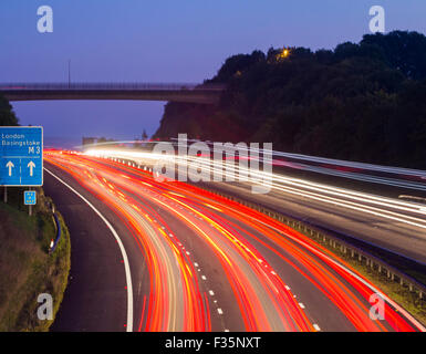 Lichtspur des Verkehrs auf der Autobahn M3 in der Nähe von Winchester, Hampshire, UK bei Sonnenaufgang. Stockfoto