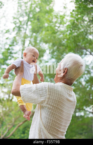 Asiatische chinesische Opa und Enkel, die Spaß am Garten. Stockfoto