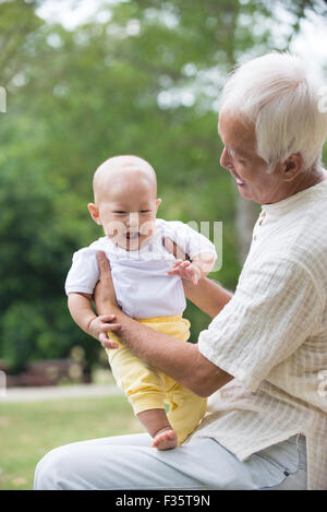 Asiatische chinesische Opa und Enkel, die Spaß am Garten. Stockfoto