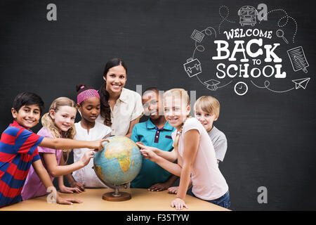 Zusammengesetztes Bild der niedlichen Schüler und Lehrer im Globe in Bibliothek suchen Stockfoto