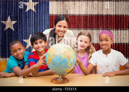 Zusammengesetztes Bild der niedlichen Schüler und Lehrer im Globe in Bibliothek suchen Stockfoto