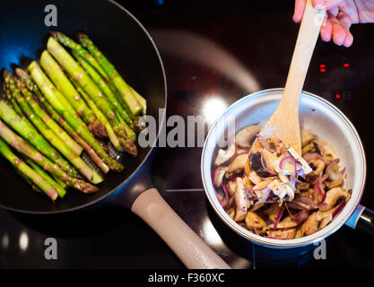 Mann, die Zubereitung cremiger Pilzsauce Stockfoto