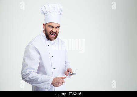 Porträt eines lustige männlichen Chef-Kochs schärfen Messer isoliert auf weißem Hintergrund Stockfoto