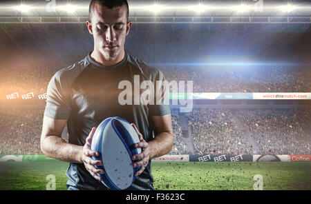 Zusammengesetztes Bild des nachdenklichen Rugby-Spieler mit ball Stockfoto