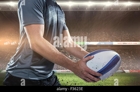 Zusammengesetztes Bild des Mittelteils des Rugby-Spieler aus schwarzem Jersey mit ball Stockfoto