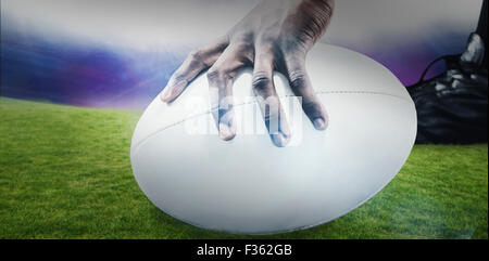 Zusammengesetztes Bild der freigestellten Bild des Sportlers mit Rugby-ball Stockfoto