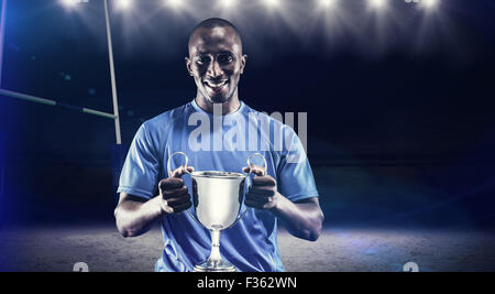 Zusammengesetztes Bild des Porträts von happy Athlet holding trophy Stockfoto